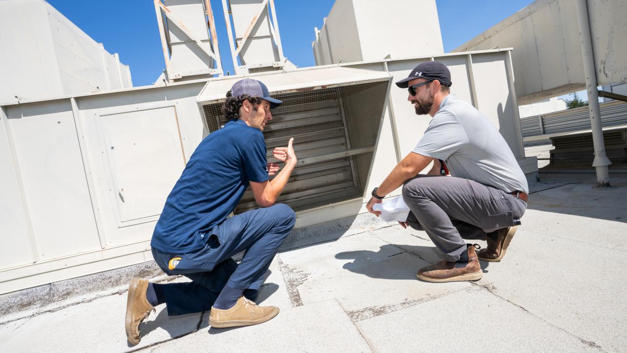 UC Davis staff from the Energy Engineering team examine air flow on top of Ghausi Hall.